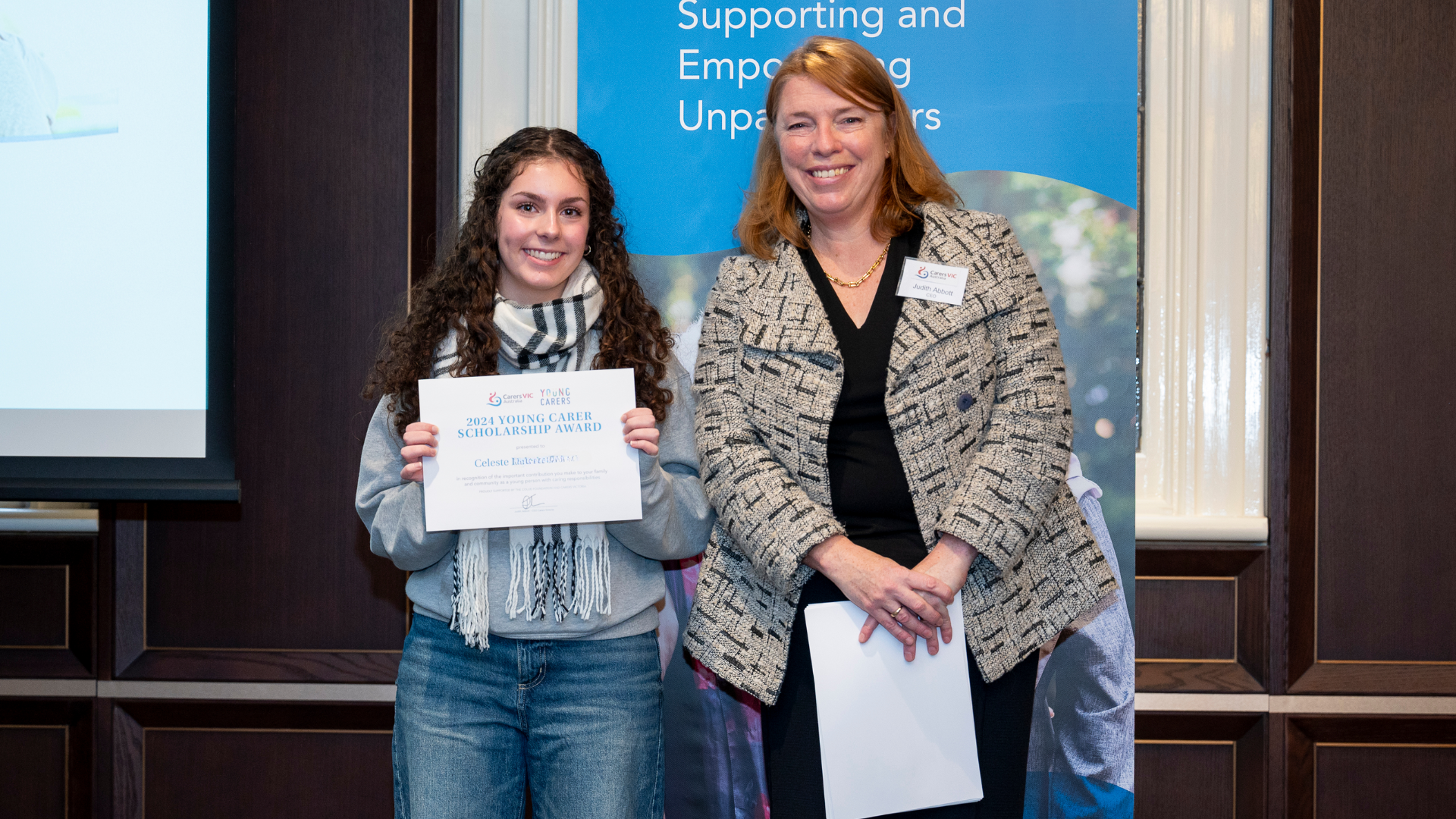 Celeste with her 2024 Young Carer Scholarship certificate, standing alongside Judith Abott, CEO of Carers Victoria