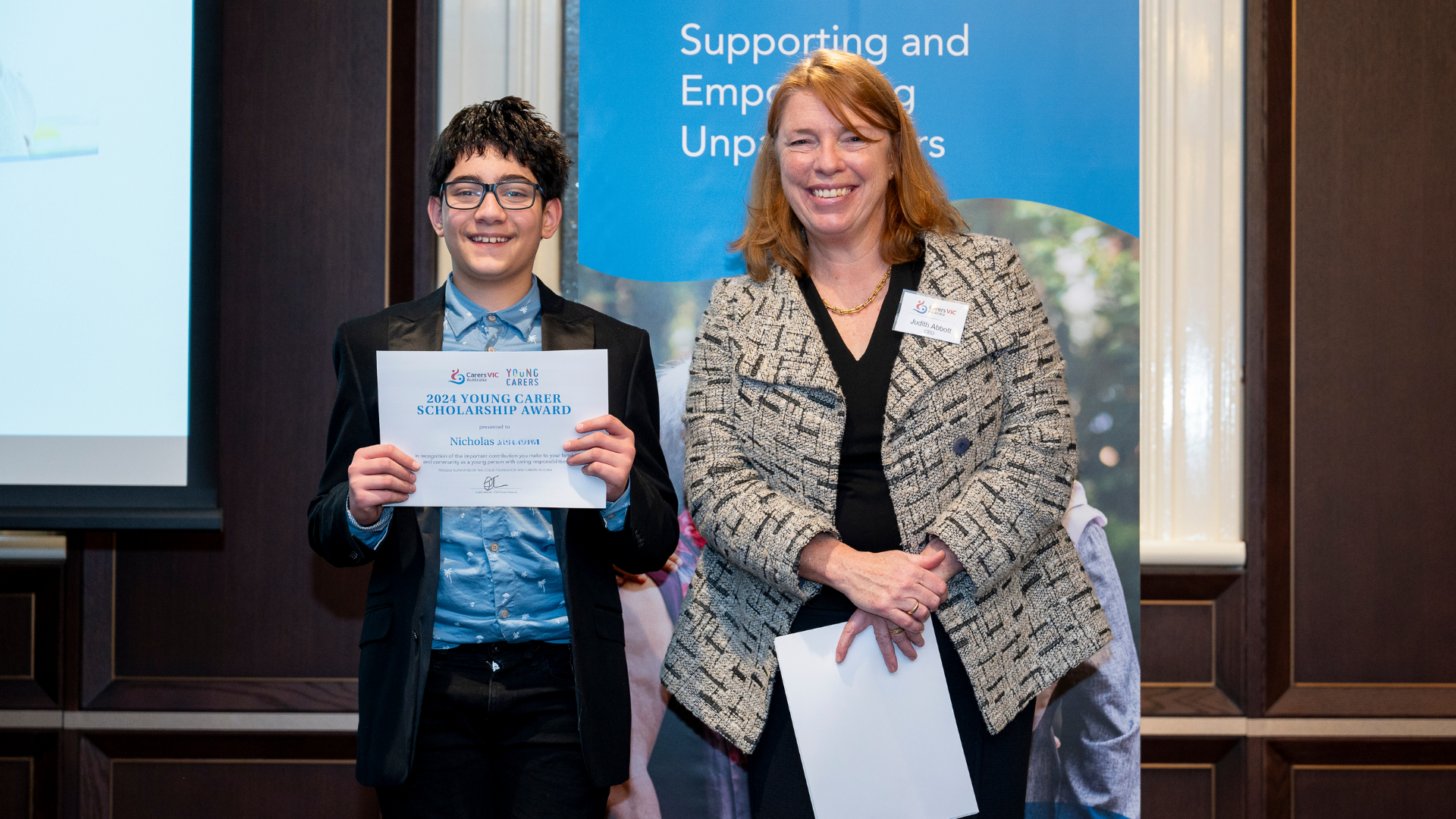 Nicholas with his 2024 Young Carer Scholarship certificate, standing alongside Judith Abott, CEO of Carers Victoria